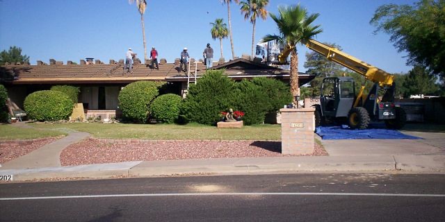 Phillips Roofing crew reroofing a Phoenix tile home with a telehandler lifting materials