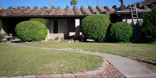 Phillips Roofing worker replacing tile on a single-story Arizona home
